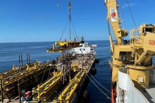 Offshore structure alongside a crane and transport vessel